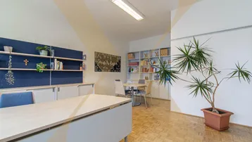 Geräumiges Büro mit mehreren Arbeitsplätzen, Besprechungsecke und hellem Holzparkettboden.