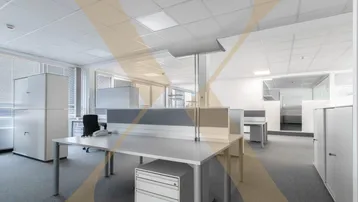 Großes, helles Großraumbüro mit modernen Arbeitsplätzen, Teppichboden und viel Tageslicht durch große Fenster.