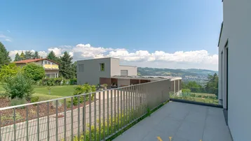 Geräumige Terrasse mit Fliesenboden und weitem Blick über die Landschaft und Berge.