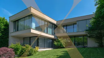 Moderne Architektur mit großen Glasflächen und gepflegtem Gartenbereich unter blauem Himmel.