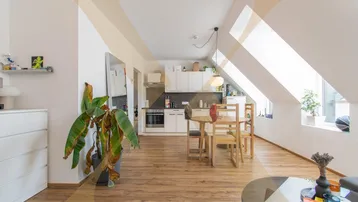Helles Dachgeschoss-Apartment mit offener Küche, Essbereich und schrägen Decken.