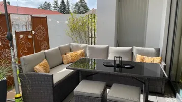 Gemütliche Terrasse mit bequemen Loungemöbeln und Sonnenschirm, ideal für entspannte Stunden im Freien.