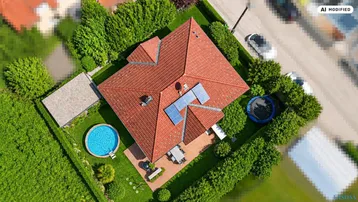 Luftaufnahme eines Hauses mit rotem Ziegeldach, Pool und Solaranlage im grünen Garten.