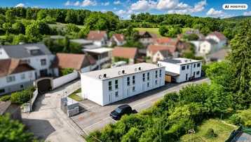 Luftaufnahme eines modernen Gebäudekomplexes in ländlicher Umgebung mit viel Grün.