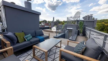 Geräumige Dachterrasse mit bequemen Loungemöbeln und weitem Blick über die Umgebung.