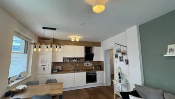 Moderner offener Wohnbereich mit integrierter Küche und Essplatz, ideal für geselliges Beisammensein.