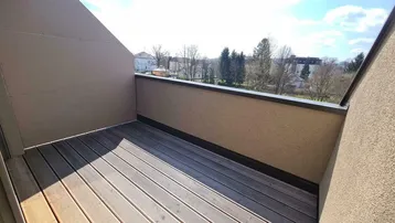 Leere Dachterrasse mit Holzboden und weitem Blick über die Landschaft.