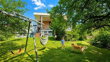 Großer, gepflegter Garten mit Spielbereich und viel Grünfläche, ideal für Familien und Haustiere.