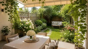 Gemütliche Terrasse mit Essbereich und Blick auf den gepflegten Garten mit weiteren Sitzgelegenheiten.
