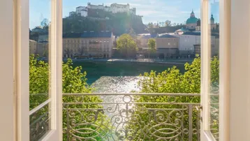 Sonniger Balkon mit weitem Blick auf die Salzburger Altstadt, den Fluss und die Festung Hohensalzburg.