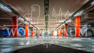 Tiefgarage mit zahlreichen Parkplätzen, beleuchtet von Neonröhren und gekennzeichnet durch orangefarbene Säulen.