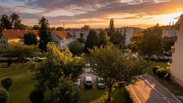 Panoramablick über die Wohngegend bei Sonnenuntergang mit grünen Bäumen und umliegenden Gebäuden.