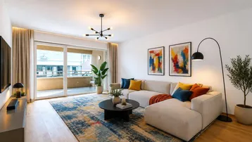 Helles Wohnzimmer mit modernem Sofa, Holzboden und Zugang zu einem Balkon.