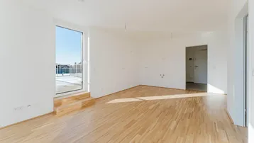 Helles, unmöbliertes Zimmer mit Parkettboden und Zugang zu einer Terrasse oder einem Balkon.