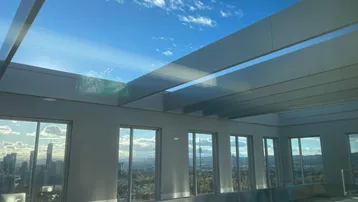 Heller, verglaster Bereich mit Panoramablick auf die Stadt und den Himmel, ideal zum Entspannen.