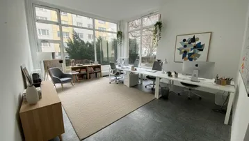Geräumiges Büro mit großen Fenstern, modernen Arbeitsplätzen und Blick auf die Umgebung.