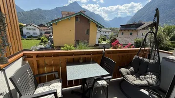 Gemütlicher Balkon mit Sitzgelegenheiten und Hängesessel, bietet einen schönen Bergblick.