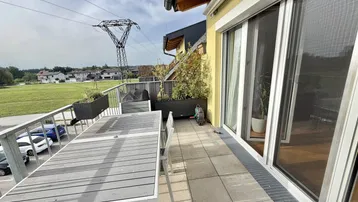 Geräumiger Balkon mit Esstisch und Stühlen, ideal für Mahlzeiten im Freien.