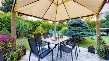 Gemütliche Terrasse mit Esstisch, Gartenmöbeln und Blick auf den Poolbereich.