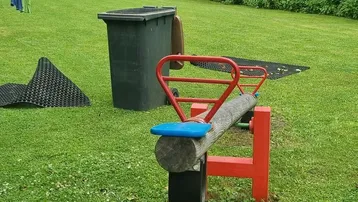 Großer Gartenbereich mit Schaukel, Trampolin und viel Grünfläche für Kinder zum Spielen.