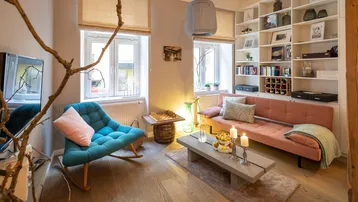 Helles Wohnzimmer mit Holzboden, bequemen Möbeln und integriertem Bücherregal.