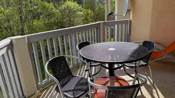 Gemütlicher Balkon mit Sitzgelegenheiten und einem schönen Blick auf die umliegende Berglandschaft.