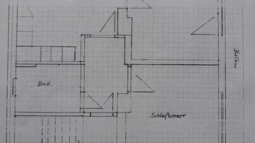 Grundriss einer Wohnung mit Wohnküche, Wohnzimmer, Schlafzimmer, Bad und Balkon.