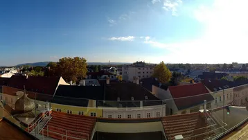 Panoramablick über die Dächer der Stadt mit weitem Horizont unter blauem Himmel.