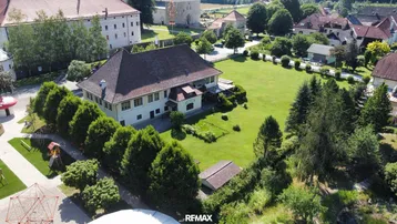 Luftaufnahme eines weitläufigen Anwesens mit großem Garten und umliegenden Gebäuden in ländlicher Umgebung.