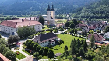 Panoramablick auf das Anwesen und die umliegende ländliche Gegend mit einer markanten Kirche.