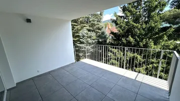 Geräumiger Balkon mit Fliesenboden und Blick ins Grüne, ideal zum Entspannen.
