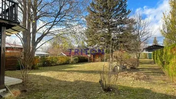 Weitläufiger Gartenbereich mit altem Baumbestand und Blick auf die Umgebung.