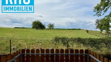 Weitläufiger Blick über grüne Wiesen und sanfte Hügel, umgeben von Natur und Ruhe.