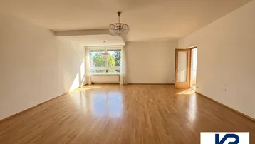 Helles und geräumiges Wohnzimmer mit Parkettboden und großen Fenstern, die viel Tageslicht hereinlassen.