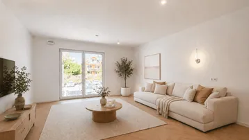 Modernes, helles Wohnzimmer mit beigem Sofa, Holzboden und Zugang zum Balkon.