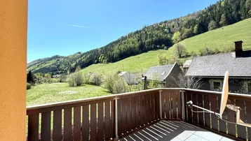 Großer Balkon mit Holzboden und atemberaubendem Blick auf die umliegende Berglandschaft.