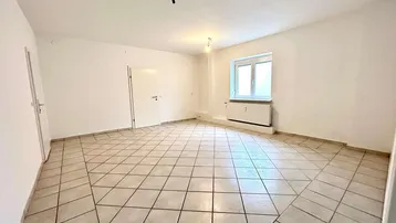 Heller, leerer Raum mit Fliesenboden und Fenster, bereit zur individuellen Gestaltung.