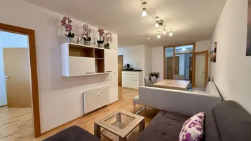 Helles Wohn- und Esszimmer mit Holzboden, gemütlichem Sofa und Esstisch.