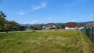 Offenes, sonniges Grundstück mit weitem Blick auf die ländliche Umgebung und entfernte Häuser.