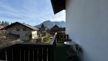 Gemütlicher Balkon mit Sitzgelegenheit und weitem Blick auf die umliegende Berglandschaft.