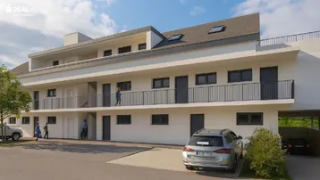 Modernes Mehrfamilienhaus mit Balkonen, Parkplätzen und Carport an einem sonnigen Tag.