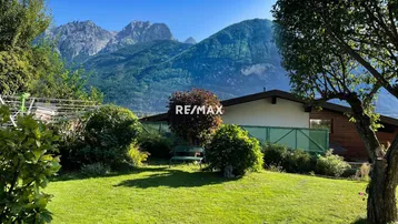 Weitläufiger Garten mit gepflegtem Rasen und beeindruckendem Panoramablick auf die umliegende Bergwelt.