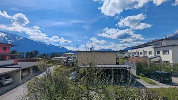 Panoramablick auf die umliegende Berglandschaft und die Siedlung unter blauem Himmel.