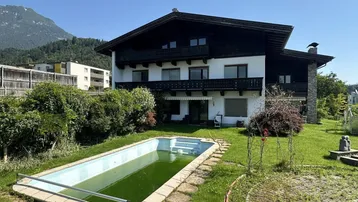 Großzügiger Gartenbereich mit Pool und Blick auf die umliegende Berglandschaft.