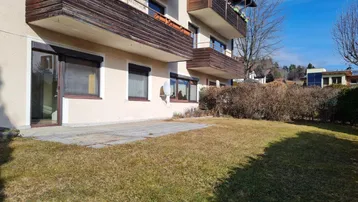 Erdgeschosswohnung mit direktem Zugang zum Garten und kleiner gepflasterter Terrasse.
