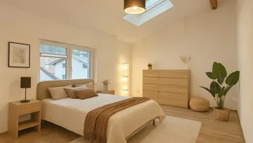 Helles Schlafzimmer mit Holzboden, gemütlichem Bett, Kommode und Dachfenster für eine angenehme Atmosphäre.