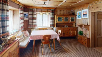 Traditioneller Essbereich mit holzvertäfelten Wänden und Decke, gemütlicher Eckbank und rustikalen Möbeln.