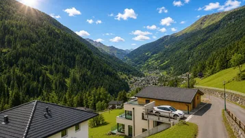 Panoramablick auf ein modernes Haus in einem sonnigen Tal mit bewaldeten Bergen.