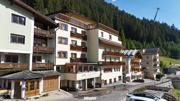 Ansicht des Hotels Silvretta mit mehreren Balkonen und der umliegenden Berglandschaft.