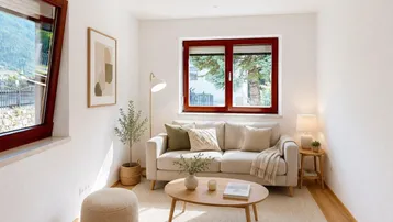 Gemütliches Wohnzimmer mit hellem Sofa, Holzboden und Blick auf die Berge.